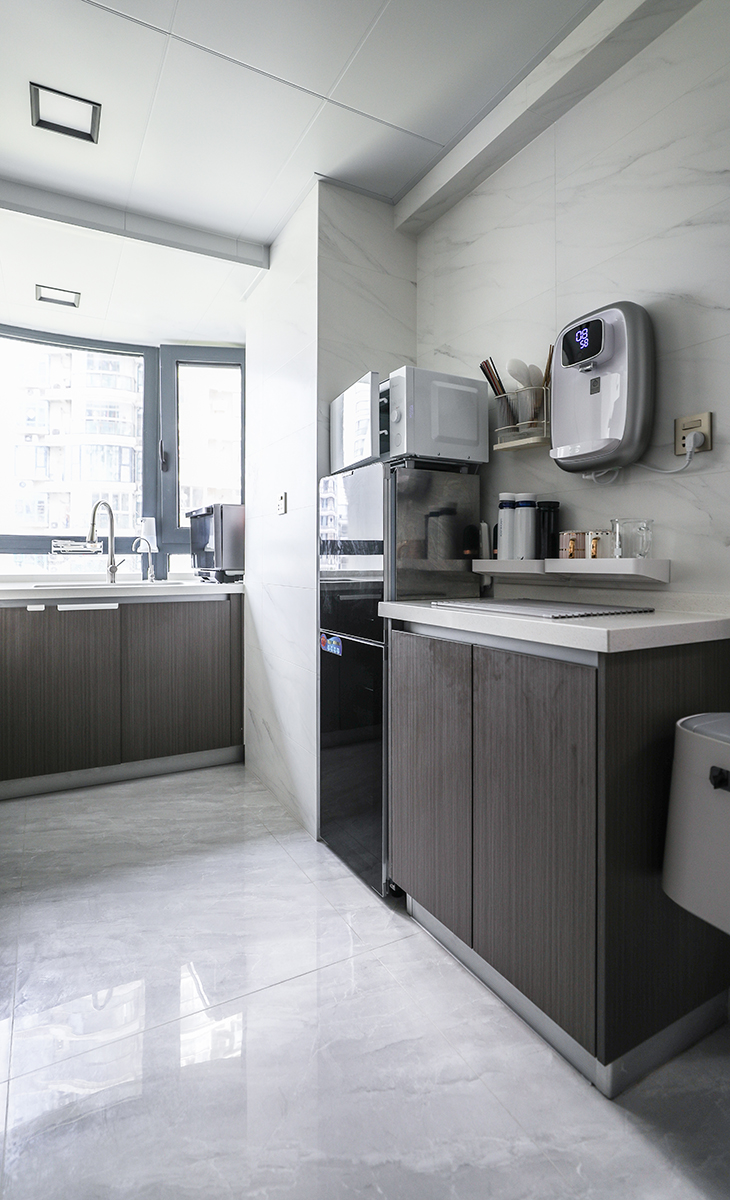 廚房設計兩個操作區，一個是中櫥水斗，一個是西櫥水斗，方便多人一起洗刷，四周白色墻面，中間做大板面磚，空間很活躍，也很實用。