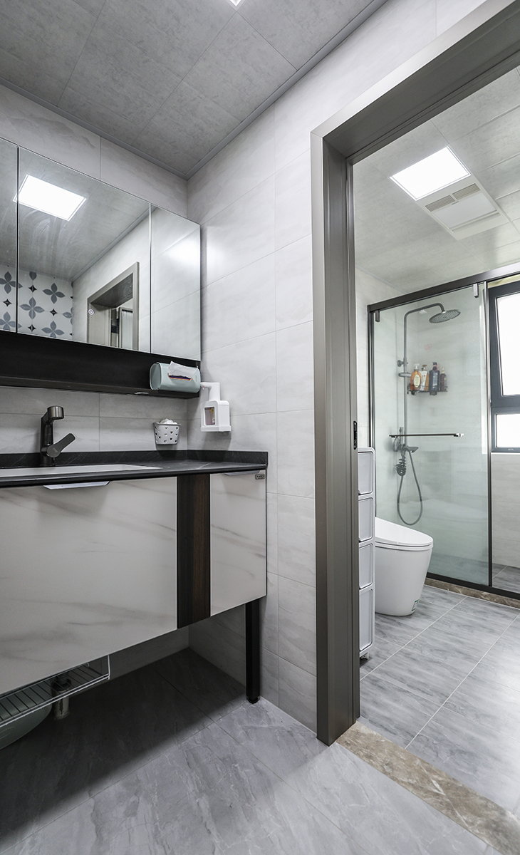 客衛空間很大，彩用干濕分離做法、濕區深灰色地磚，干區藝術磚、白色吊頂，鈦合金移門，體現主人高檔次的生活品味和優雅的審美觀。
