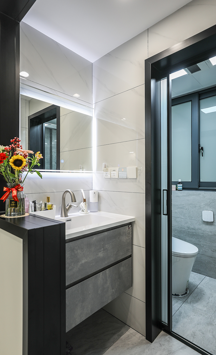 衛生間干區也是比較搶眼的地方，黑色鈦合金的門套凸顯高級感，半墻的設計，不僅顯得空間大，還可以放裝飾物，實用