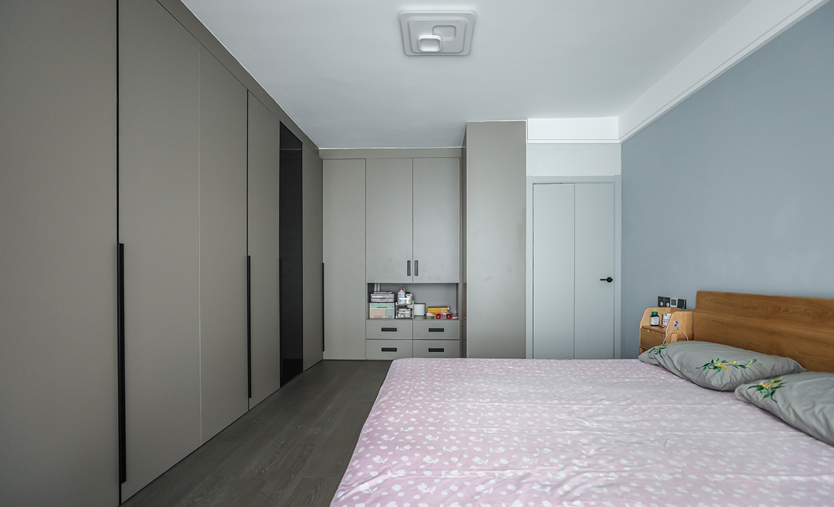 次臥是父母的空間，比較簡潔，做一個L型開放式衣帽間，墻面藍色乳膠漆，色彩上干凈、簡煉，空間上靈活自如，簡潔明亮。