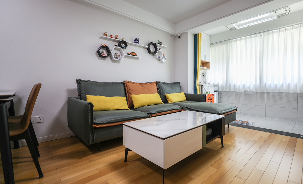 沙淺灰色沙發(fā)框架+橙色座墊讓客廳的氛圍年輕起來了，沙發(fā)背景墻黑白配層板裝飾，代替?zhèn)鹘y(tǒng)的壁畫，使空間上更加飽滿。