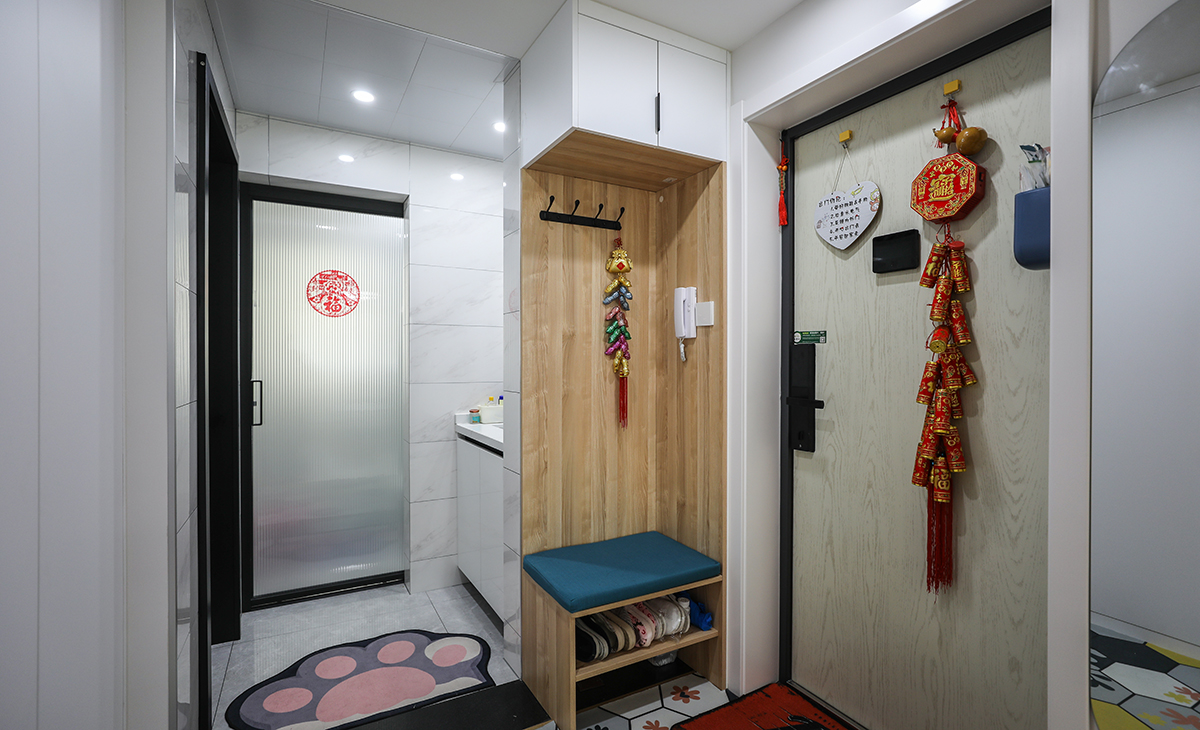 本套房子的玄關(guān)設(shè)計(jì)也是一大亮點(diǎn)，入戶玄關(guān)是一個(gè)緩存過度地段，門口的換鞋凳方便換鞋，加上掛大衣外套的功能，使空間更加完善。