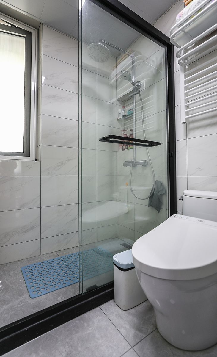 衛(wèi)生間空間不是很大，彩用干濕分離做法，可以滿足干濕區(qū)同時(shí)使用，而不影響到對方，地面深灰色地磚，白色吊頂，鈦合金移門，配上衛(wèi)洗麗馬桶和電熱毛巾架，更加合理的衛(wèi)浴空間。