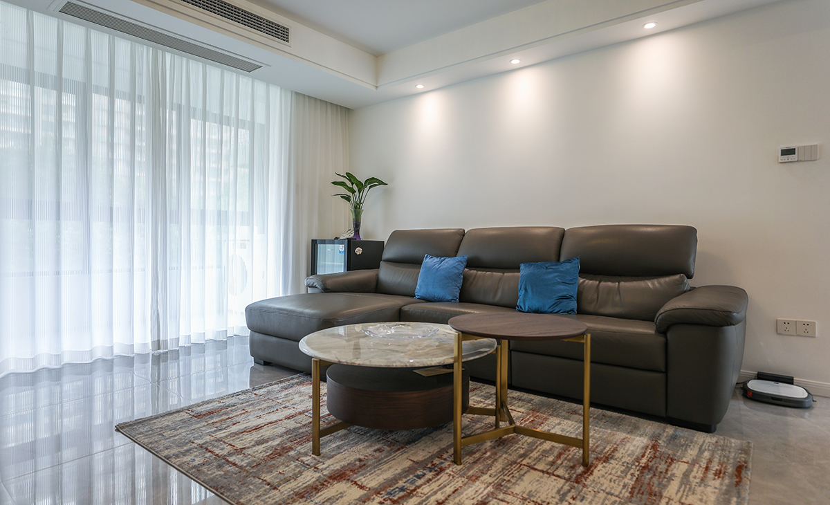 沙發(fā)背景刷米灰色涂料，白色的沙簾，沙發(fā)背景留白設(shè)計(jì)，色調(diào)上墻面涂料和窗簾用淺色，沙發(fā)用深色，深淺搭配的錯落有致，既溫馨又簡潔。
