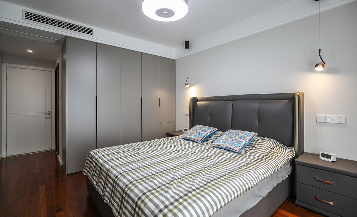 主臥原實(shí)木地板保留，所以床選擇的是深色，衣柜門板也是深色，這樣和原來的實(shí)木地板進(jìn)行搭配，就不會那么突兀，頂面圓型吊扇燈，實(shí)現(xiàn)方中有圓，圓中有方，造型以簡潔平板為主，方便打理，體現(xiàn)了簡約風(fēng)格的簡潔、隨意，不拘一格。