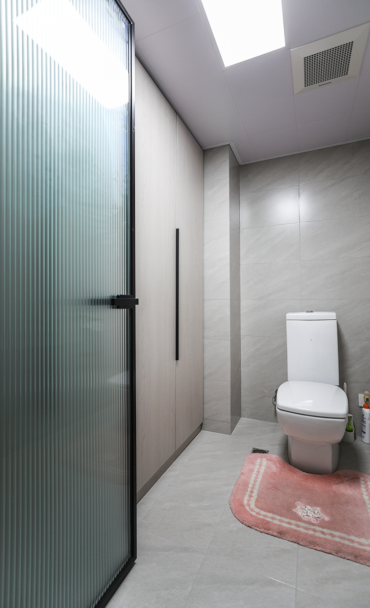 主衛(wèi)空間也很大，只放一個馬桶，一個洗手臺，做一排儲物柜，增加主人的收納空間，黑色邊框長虹玻璃門，讓整個空間協(xié)調(diào)統(tǒng)一，大氣時尚，主人很滿意，不斷地夸贊設(shè)計(jì)師對色彩的精準(zhǔn)把握。