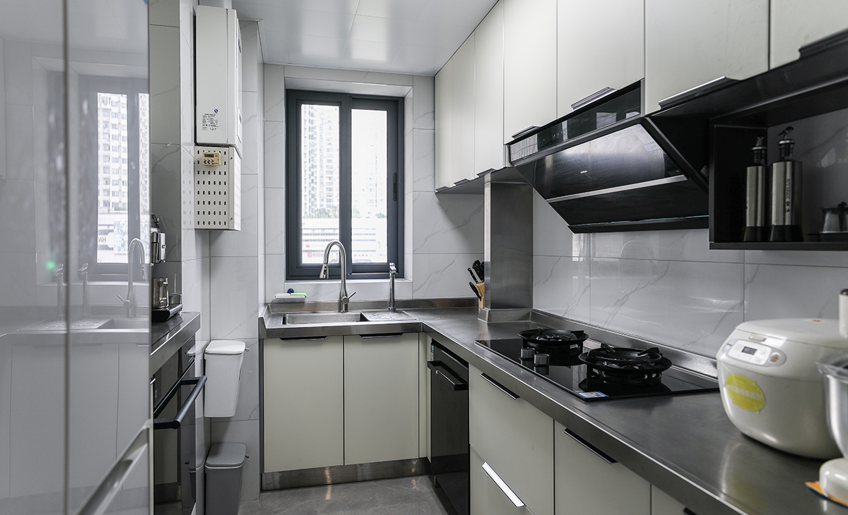 廚房空間很大，L型兩面櫥柜，另外冰箱邊上也有操作臺，顏色簡潔明快，材質(zhì)要干凈和好打理，白色的吊頂和米色的櫥柜相呼應(yīng)，不銹鋼臺面經(jīng)久耐用，各種廚房電器全部配齊，滿足主人制作各種美食的需求。