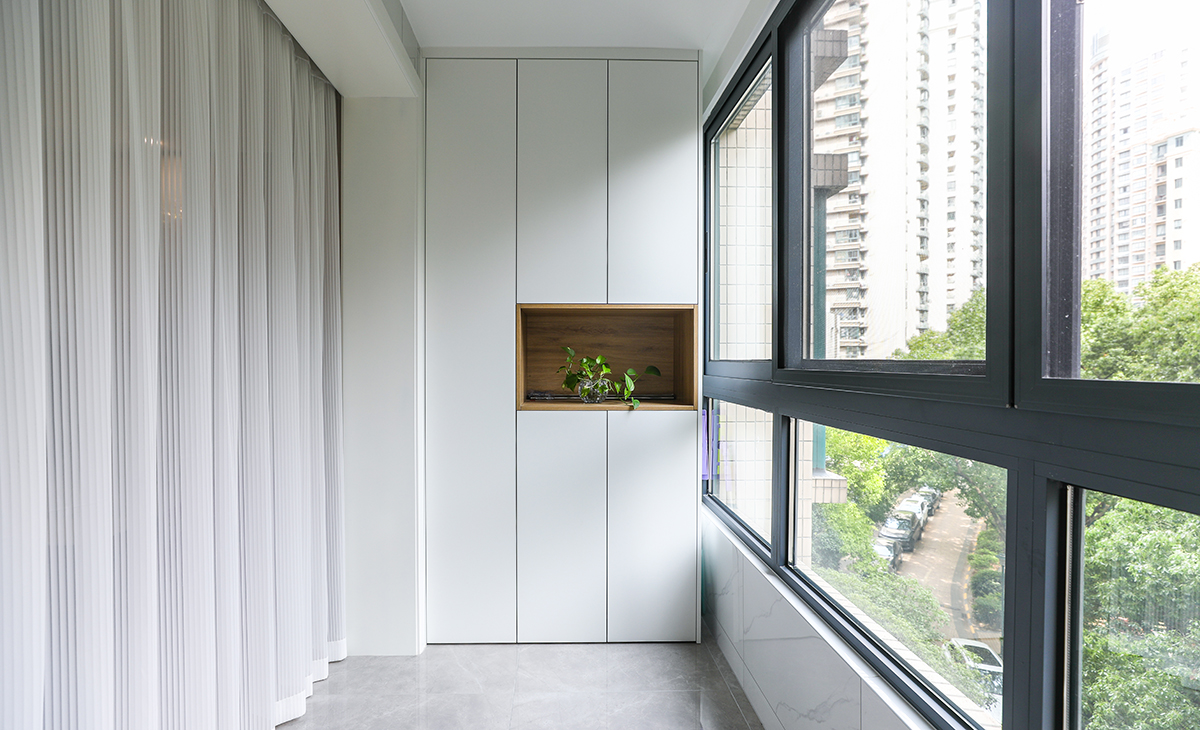 陽臺是晾曬衣物的場所，一側(cè)洗衣機(jī)和水池，一側(cè)為儲物柜，顏色以白色為主，儲物柜白色門板和門套相搭配，超大玻璃窗讓陽光柔和的照進(jìn)來，很舒適、很愜意。
