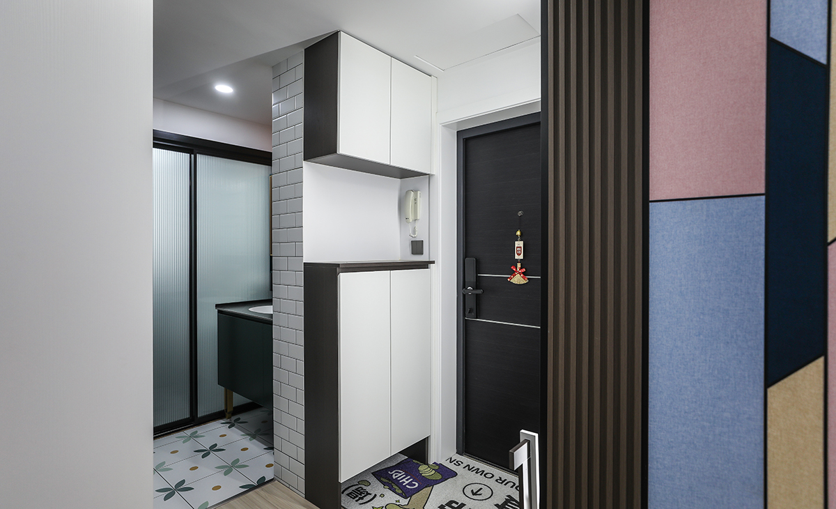 進門玄關柜的設計也是一大亮點，上下完全分層，黑色柜體、白色門板，讓玄關看的更簡單大氣，又拉伸了玄關的空間感。