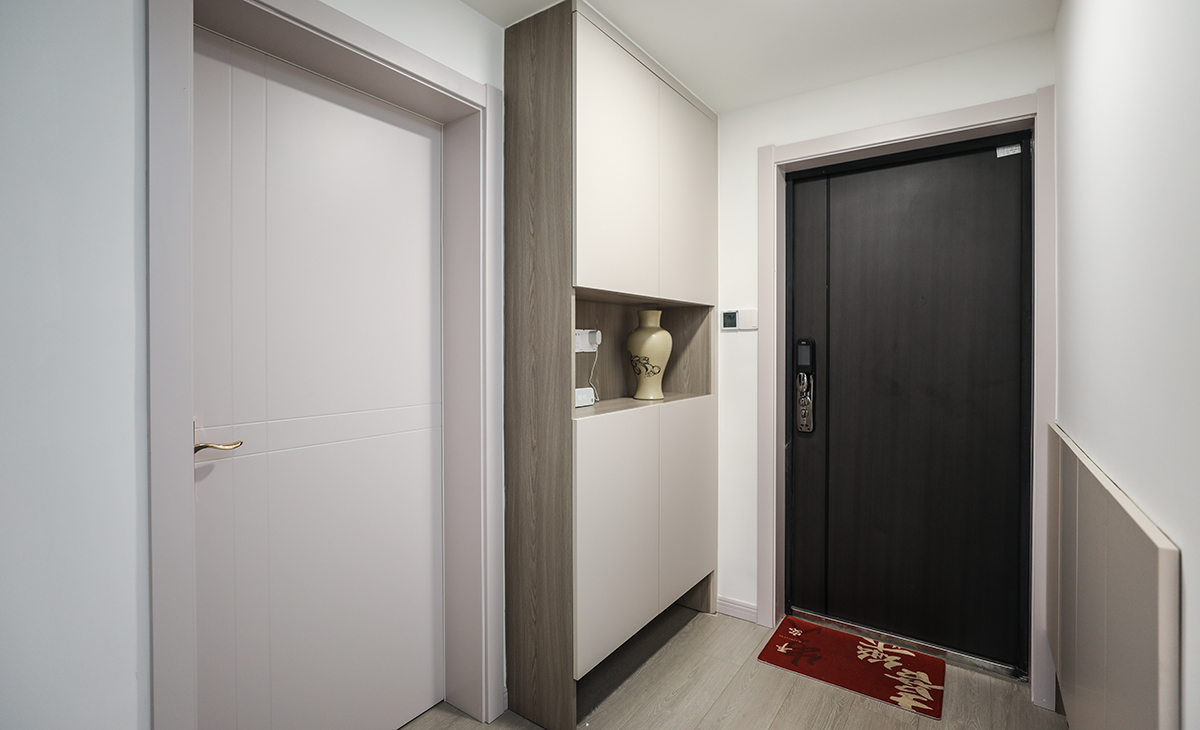 進門玄關柜的設計也是一大亮點，進門左側下方鞋柜和儲藏間柜子共用一面墻體，做到了空間利用的最大化。中間鏤空的鞋柜柜體，給客戶提供了展品區，是進戶歸家第一道風景；下方鏤空設計，進戶臨時儲鞋干凈整潔。