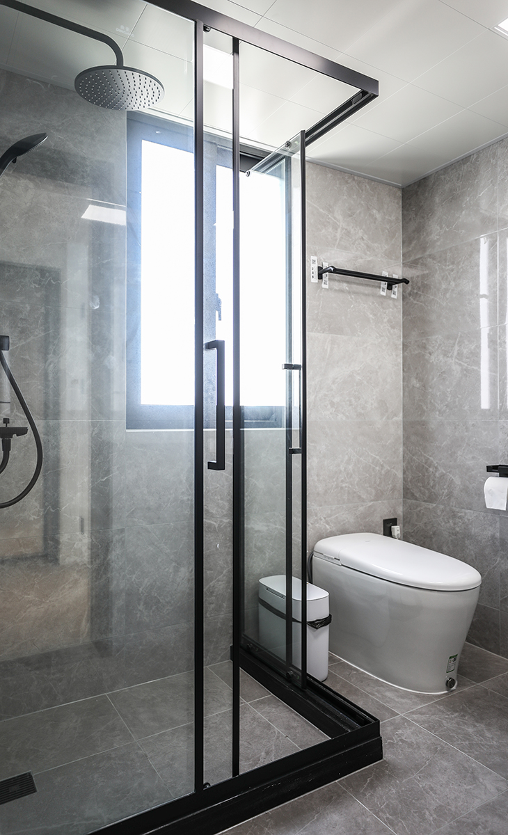 臥室里的衛生間，采用L型的直角淋浴房，兩邊都能移動，解決了主人擔心的出入空間狹小的問題，墻地同色的淺灰色瓷地磚搭配，讓整個空間顯得大氣有檔次，滿足了主人的高端品味追求。