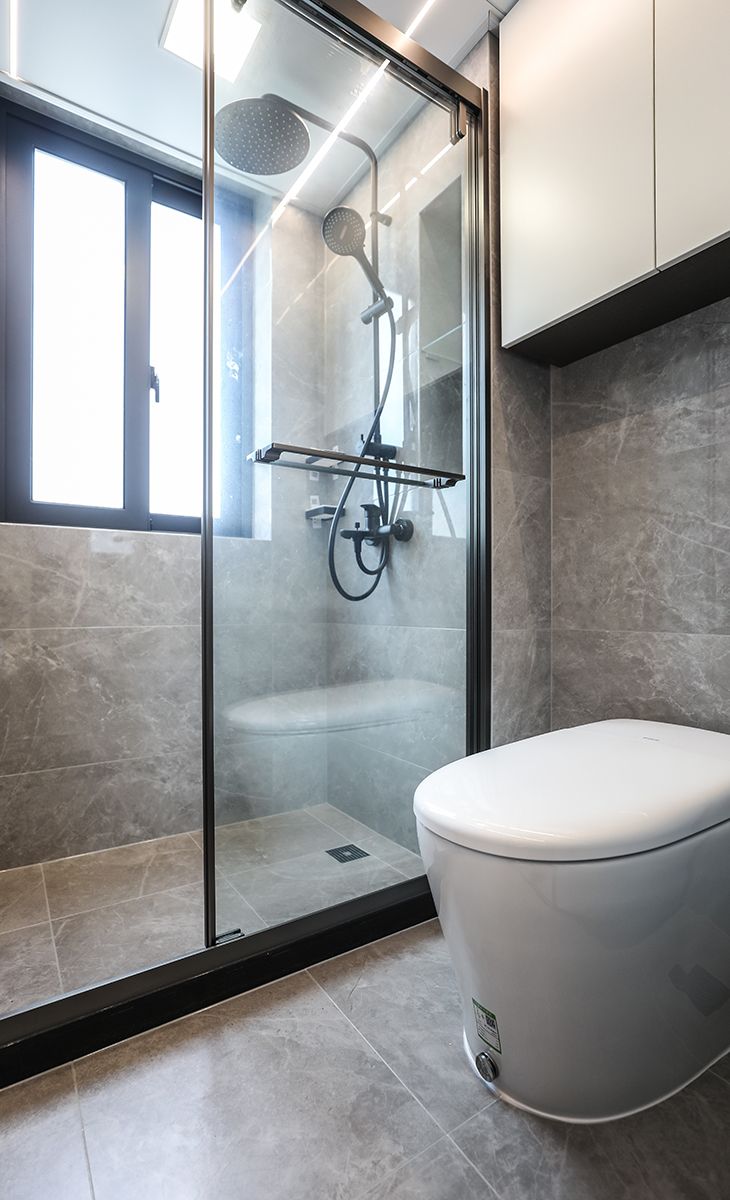 位于通道上的客衛生間，采用了干濕分離的設計，將空間合理劃分。通過防水柜體與長虹玻璃組合來進行隔斷，增加收納的同時也將空間延伸，吊頂采用小方燈加線燈的組合，更具線條美。