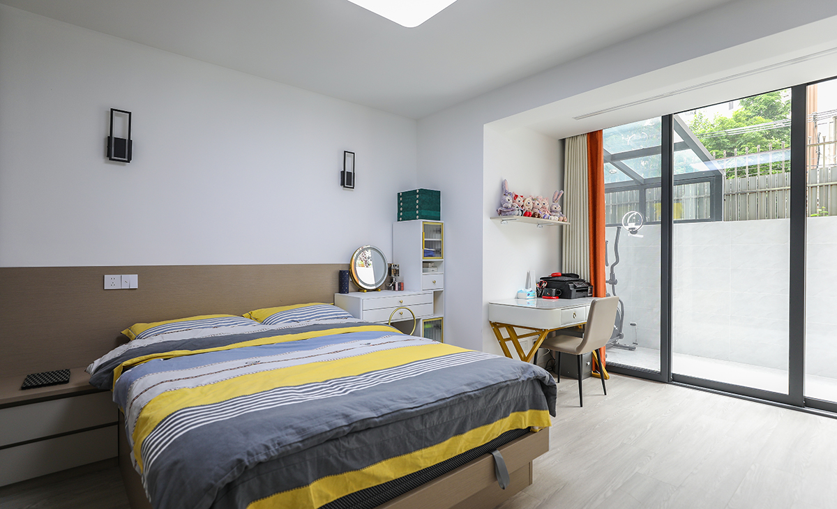 臥室整體采用簡約色彩搭配，床頭背后一面墻采用一半深色乳膠漆，有主次分明的界限感，梳妝臺(tái)代替床頭柜的使用功能，節(jié)省空間。