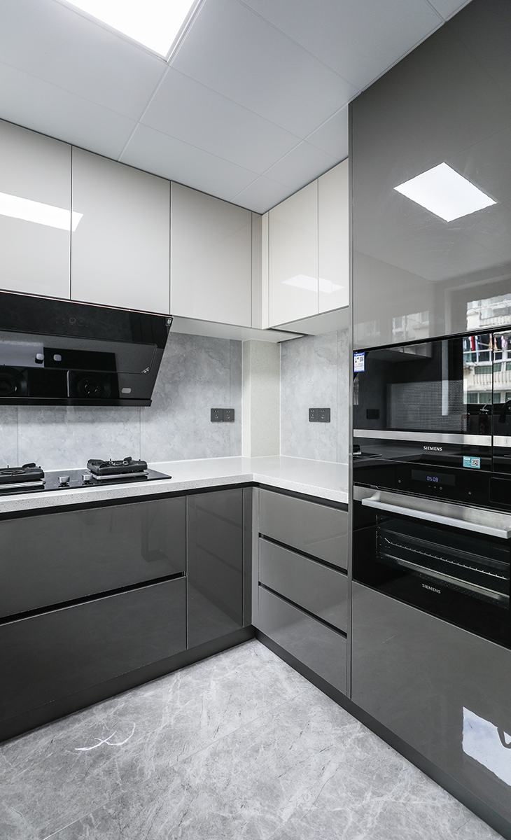 廚房空間很大，原本L型的櫥柜后期改成了U字型，雙開門的冰箱放在了外面的餐邊柜邊上，廚房灰白色調(diào)，下柜打理衛(wèi)生方便，上柜白色吊柜滿做也不壓抑，還做了一面立柜蒸烤箱取物不用彎腰，下柜和上柜又有很多儲物。