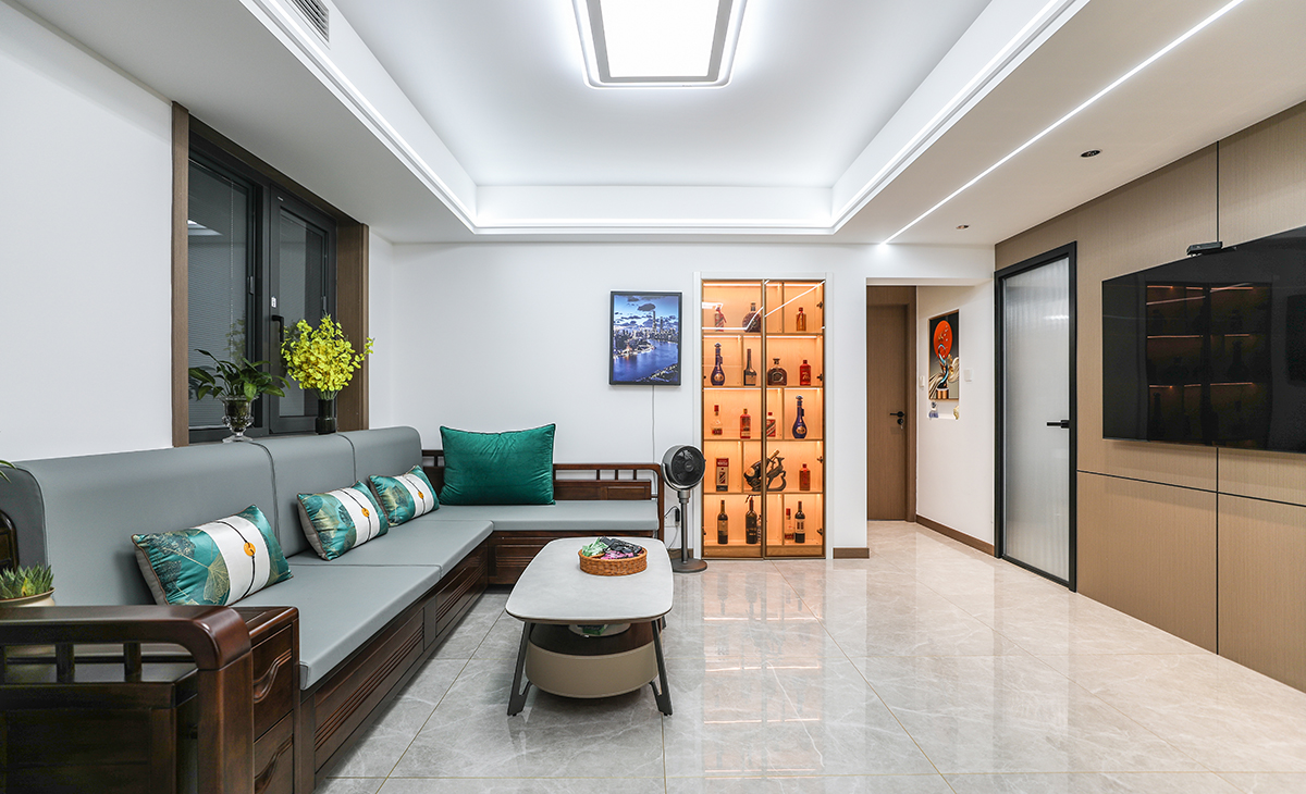 在一個(gè)家庭中，客廳是連接內(nèi)外和溝通客主情感的主要場(chǎng)所，利用頻率較高，所以在空間上也相對(duì)比較大。客廳比較寬敞，整體墻面用白色乳膠漆，電視墻做木飾面，用原木色木飾面凸出暖色調(diào)，明暗相間，實(shí)木沙發(fā)立刻檔次提高很多，借助原戶型結(jié)構(gòu)，放一組貴妃沙發(fā)。地面采用淺灰色地磚，吊頂造型上采用雙眼皮吊頂和線性燈設(shè)計(jì)。