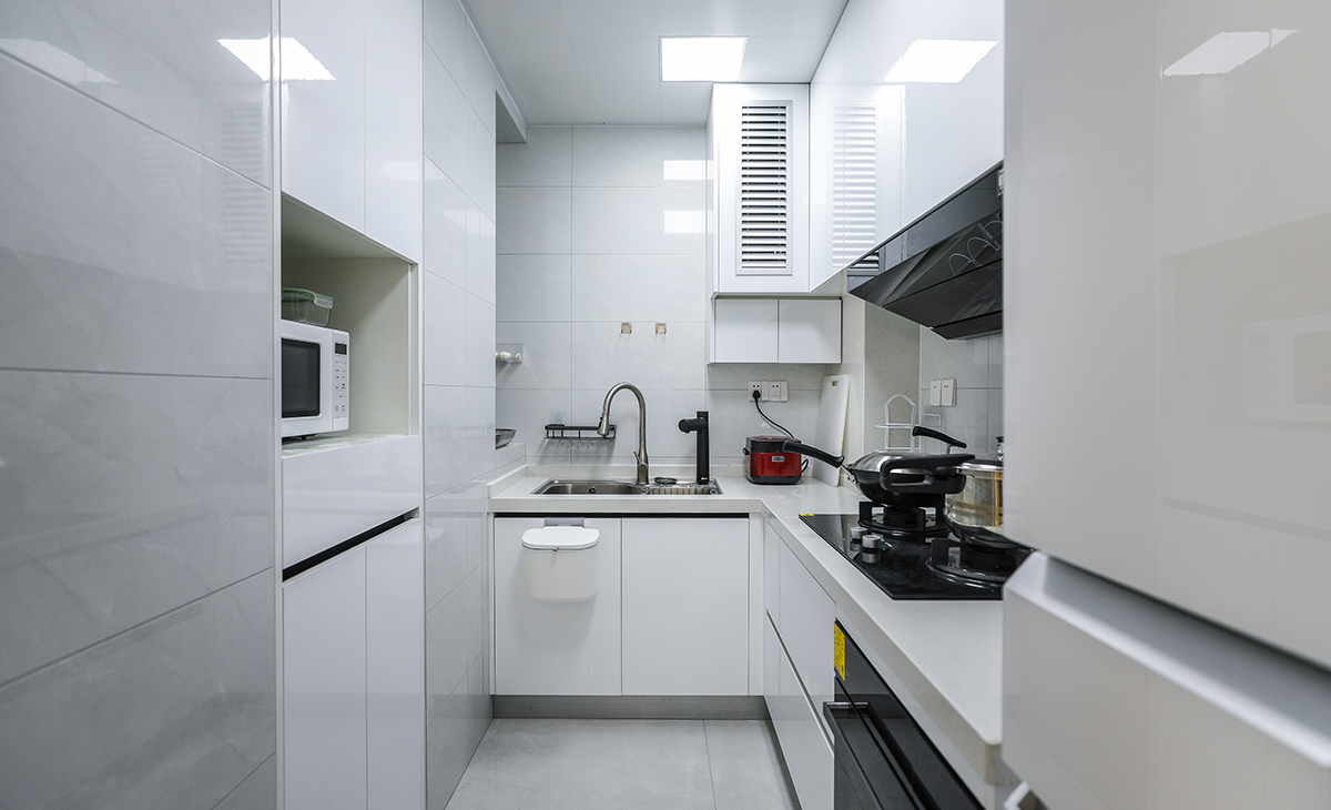 廚房空間很大，L型兩面櫥柜，另外冰箱邊上也有操作臺，顏色簡潔明快，材質要干凈和好打理，白色的吊頂和白色的櫥柜相呼應，石英石臺面經(jīng)久耐用，各種廚房電器全部配齊，滿足主人制作各種美食的需求。