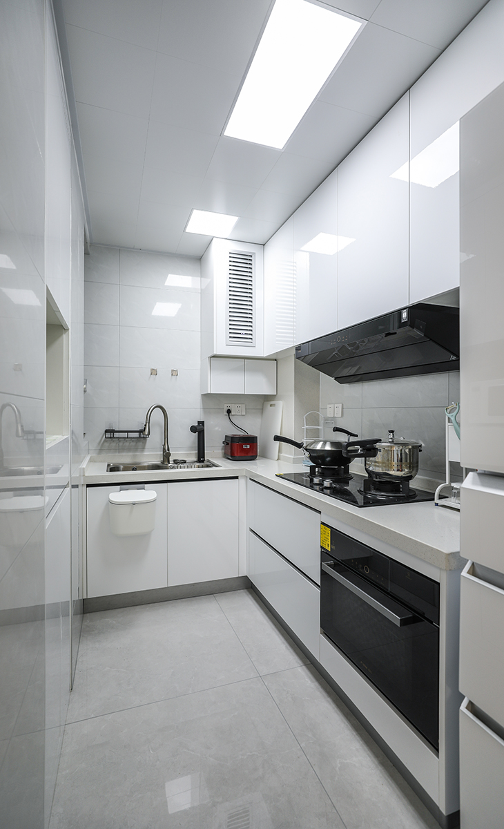 廚房空間很大，L型兩面櫥柜，另外冰箱邊上也有操作臺，顏色簡潔明快，材質要干凈和好打理，白色的吊頂和白色的櫥柜相呼應，石英石臺面經(jīng)久耐用，各種廚房電器全部配齊，滿足主人制作各種美食的需求。