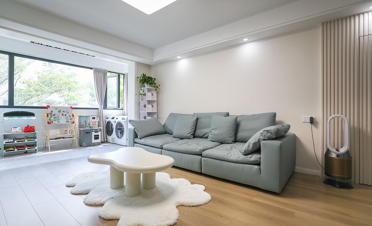 客廳的色彩搭配為墻淺地深的配色理念，這樣對于整體性有不可忽視的效果，沙發(fā)的背面做了木格柵裝飾，讓原本單調(diào)的墻面有了生機(jī)。