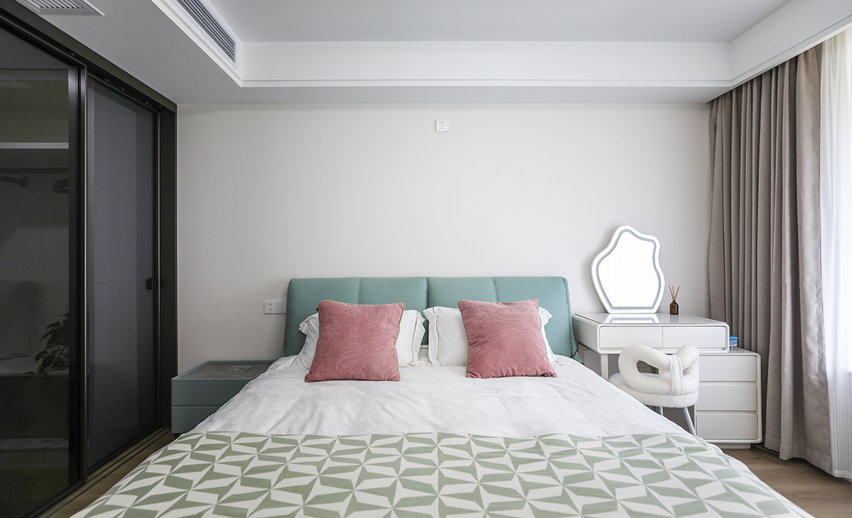 臥室整體采用簡約色彩搭配，床頭背后一面墻采用淺色乳膠漆，窗簾顏色深一些有主次分明的界限感，梳妝臺代替床頭柜的使用功能，節(jié)省空間。