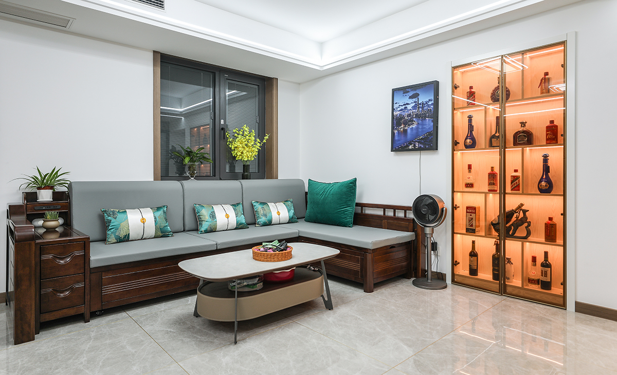 在一個家庭中，客廳是連接內外和溝通客主情感的主要場所，利用頻率較高，所以在空間上也相對比較大。客廳比較寬敞，整體墻面用白色乳膠漆，電視墻做木飾面，用原木色木飾面凸出暖色調，明暗相間，實木沙發立刻檔次提高很多，借助原戶型結構，放一組貴妃沙發。地面采用淺灰色地磚，吊頂造型上采用雙眼皮吊頂和線性燈設計。進門的多功能儲物柜絕對是房子的點睛之筆，做了鞋柜或者衣帽間，讓開口的空間具有儲物功能，在布局上也更加合理。