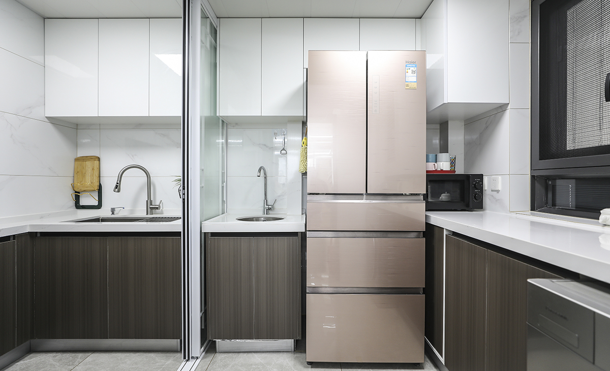 廚房空間很大，簡約的廚房設計，顏色的選擇不會太復雜，白色是常用到元素，使空間有了留白的感受，使用白木與灰木紋色，讓視覺的焦點停留在這上面，線條干凈利落。并且是中西廚兩相結合，中式菜肴在中廚里實用，隔絕了油煙的問題。