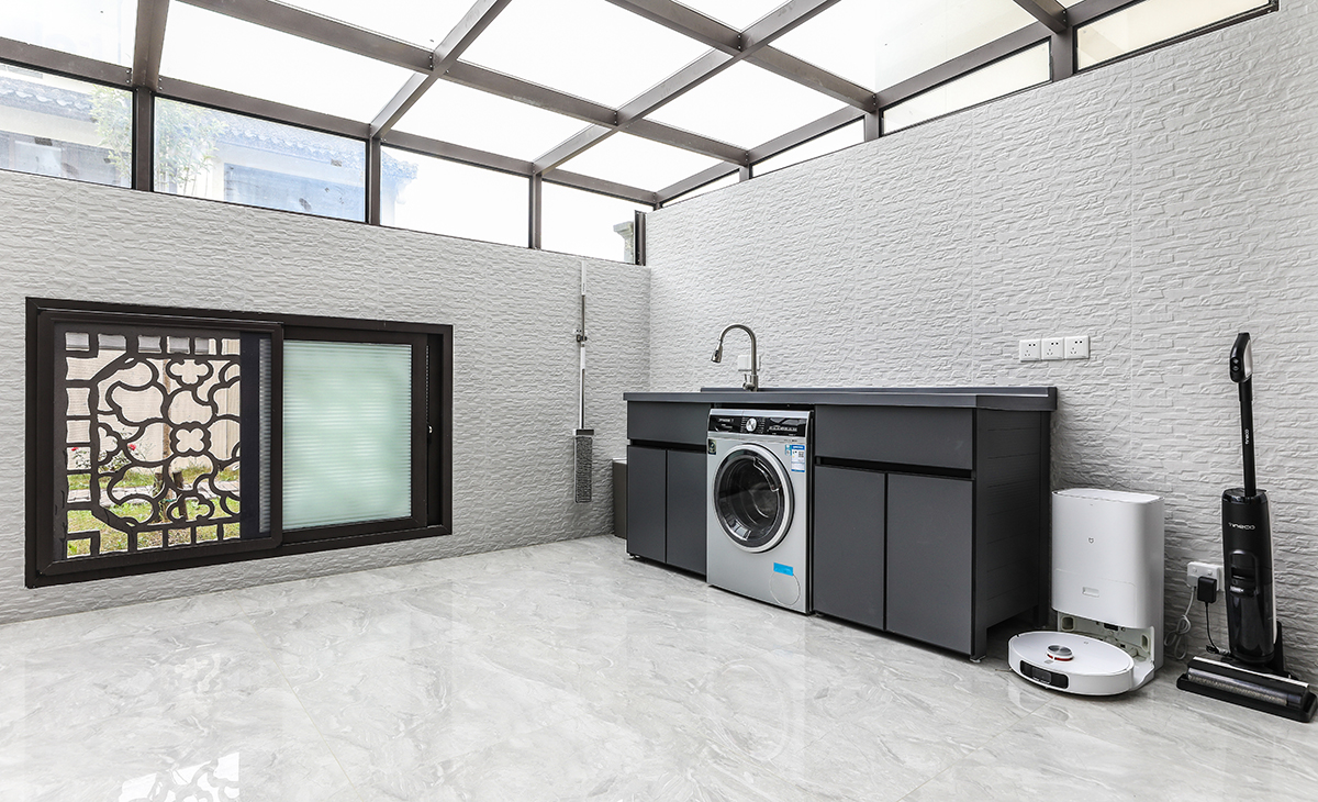 北露臺是晾曬衣物的場所，一側洗衣機和水池，一側為儲物柜，超大玻璃窗讓陽光柔和的照進來，很舒適、很愜意。顏色以白色為主，陽露臺為休閑，白墻黛瓦馬頭墻,回廊掛落花格窗。