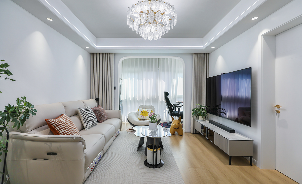 客廳開(kāi)間很大，淺灰色皮質(zhì)沙發(fā)立刻檔次提高很多，放一組懶人沙發(fā)，客廳空間也很寬闊。吊頂造型上采用單眼皮吊頂。地面采用原木色地板。造型和色調(diào)上無(wú)不給人以簡(jiǎn)潔、時(shí)尚的感覺(jué)。