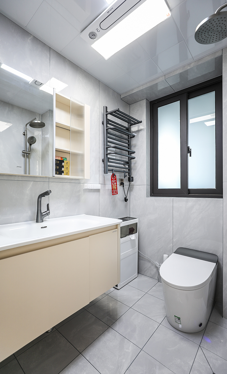 主衛空間也很大，只放一個馬桶，一個洗手臺，不單獨做淋浴區，讓空間顯得更寬敞，灰色的窗戶配上槍灰色墊毛巾架、槍灰色龍頭，讓整個空間協調統一，大氣時尚，主人很滿意，不斷地夸贊設計師對色彩的精準把握。