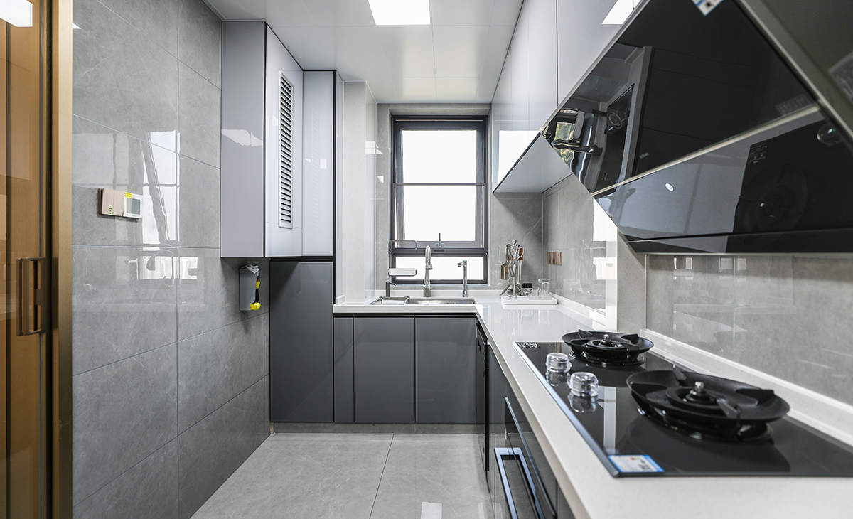 該套房子廚房空間很大，L型兩面櫥柜，另外冰箱邊上也有操作臺，顏色簡潔明快，材質要干凈和好打理，白色的吊頂和淺色的櫥柜相呼應，各種廚房電器全部配齊，滿足主人制作各種美食的需求。