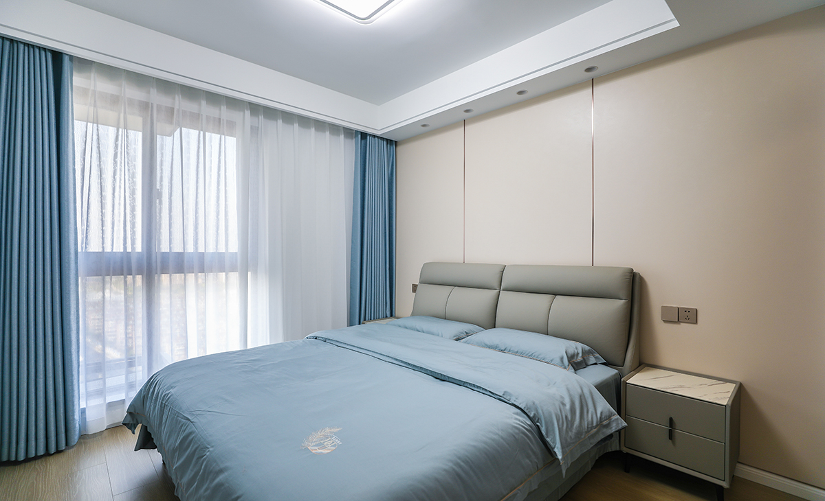 客房有L形衣帽間，平時做儲藏室用，1.8米的床配上70寸電視，讓家里老人來串門時住的安心。同樣做了奶咖色竹木纖維板床頭背景墻，不擔心客人來居住時弄臟床頭墻面。