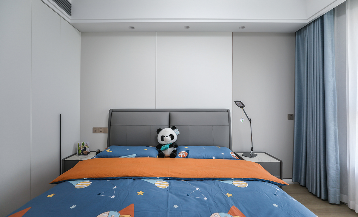 次臥是公子房，1.8米灰色皮包床保證小朋友睡覺充足翻身空間，睡的安心，衣柜區域正對進門區做一排玻璃門，里面可以放小朋友的玩具和書本，床頭背景墻米白色結合淺灰色竹木纖維墻板，既讓奶白色柜門和墻面、頂面渾然一體，同時呼應了灰色床、床頭柜，整個次臥看起來高大尚。