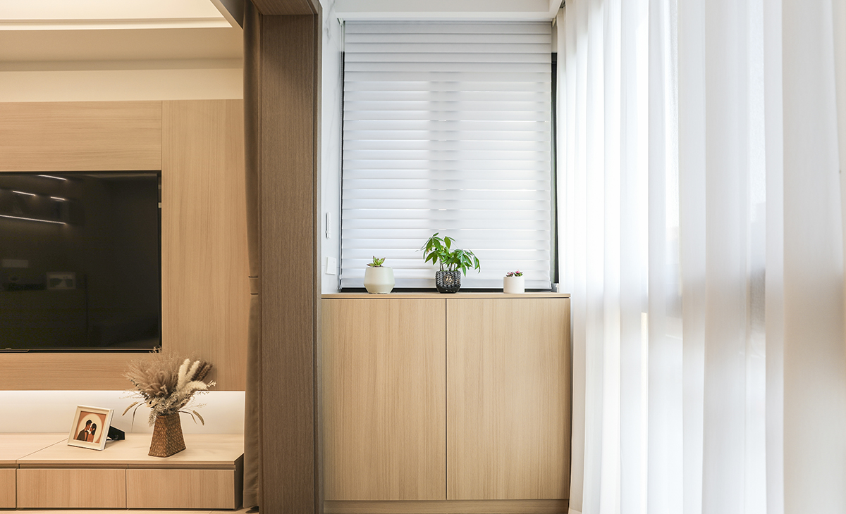 陽臺作為生活的晾曬衣物場所，它不僅有收納和洗衣服功能，整體空間設(shè)計好以后，效果更突出，也能作為觀賞的一處景物。原木色柜體和門板做了當(dāng)下很流行的洗衣柜組合，上面的收納柜和對面的儲物柜形成了鮮明的對比，長長的收納柜，既可以放吸塵器，又美觀簡約時尚，配上白色紗簾，把原木色的風(fēng)格，簡單明了的凸顯出來，既時尚又溫馨，達(dá)到了業(yè)主想要的美觀和實用并存的效果。