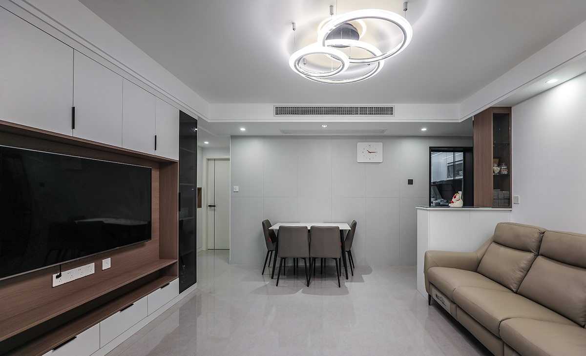 客廳和餐廳連在一起，空間合理規劃將餐廳和客廳分開，風格以簡約風格為主，地面鋪淺灰色的80*80的地磚，頂面做中央空調，整個的吊頂以簡約的線條為主。