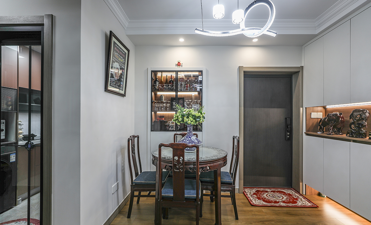 原有進戶門在左邊，現門洞位置之前為窗戶，為了避免餐廳在衛生間門口的尷尬，以及外面與對面房子門對門沖突的因素。現把入戶門與窗更換位置，原門洞做一組裝飾餐邊柜，上面做玻璃門+燈帶展示。下面儲物