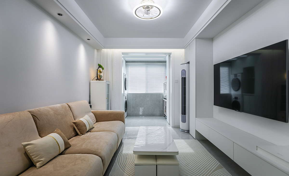 客廳以簡潔實用為主，地面瓷磚通鋪至陽臺，拆除原有移門，空間整體更顯寬敞，墻面乳白色涂料搭配，層次分明，簡約大氣，頂面采用走邊，不做復雜吊頂，讓有限的空間整體線的簡單明亮大氣。給人整體感覺寬敞明亮。