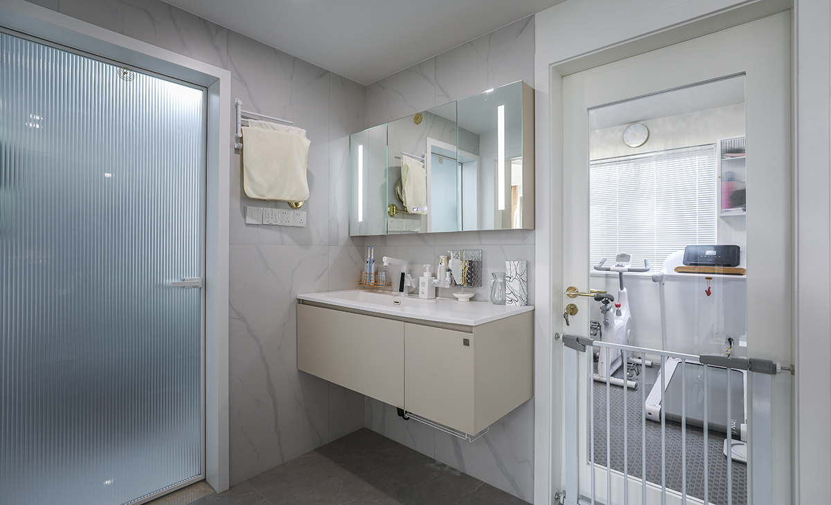 衛生間做干濕分開，淋浴區利于原有管道做壁龕增加儲物的同時合理利用每一份空間，馬桶上增加儲物柜，增加收納空間，金色窄框淋浴房，線條簡單，墻地面通鋪一體大磚，單獨淋浴區同色小磚做下水坡度。讓整個空間協調統一，大氣時尚