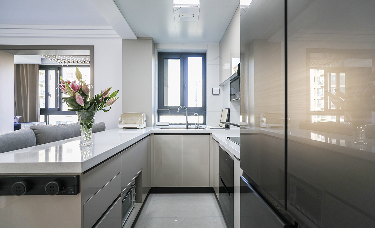 　該套房子廚房空間很大，U型兩面櫥柜，另外冰箱邊上也有操作臺，顏色簡潔明快，材質要干凈和好打理，白色的吊頂和米色的櫥柜相呼應，石英石臺面經久耐用，各種廚房電器全部配齊，滿足主人制作各種美食的需求。