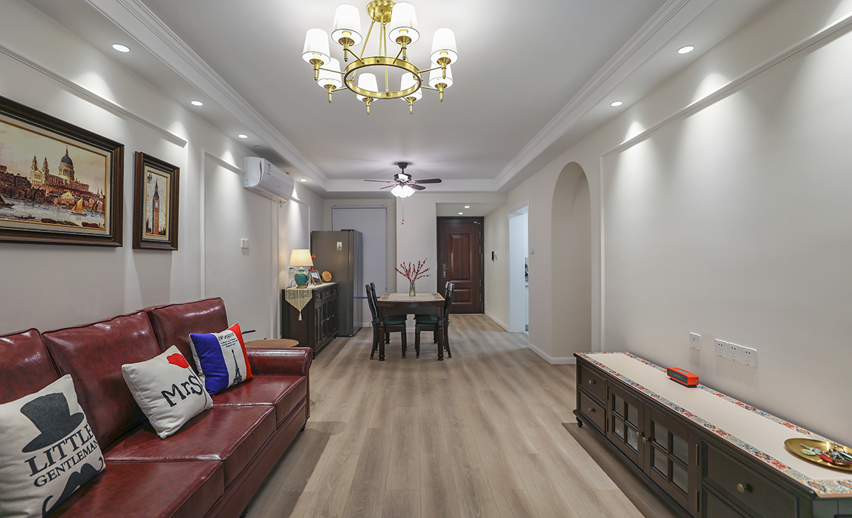 高飽和度的皮質(zhì)沙發(fā)把復(fù)古的格調(diào)演繹出來，吊燈和落地?zé)舻倪x擇都共同打造油畫一樣的美感氛圍。暖色調(diào)的墻漆和地面瓷磚相呼應(yīng)，懸掛背景墻上的裝飾畫更是恰到好處，精心挑選的畫框和位置，提升整體設(shè)計(jì)效果。美式復(fù)古風(fēng)的濃郁風(fēng)情在這個(gè)客廳的種種細(xì)節(jié)里，體現(xiàn)的非常充分。