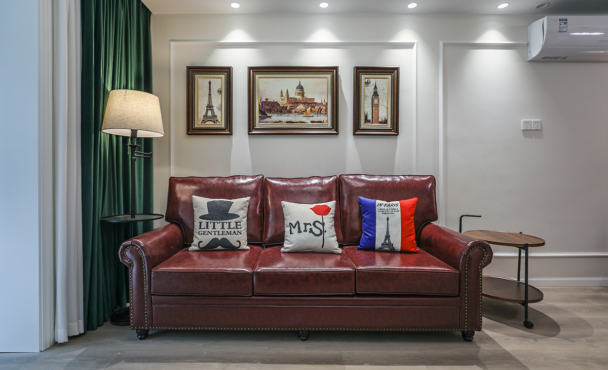 高飽和度的皮質(zhì)沙發(fā)把復(fù)古的格調(diào)演繹出來，吊燈和落地?zé)舻倪x擇都共同打造油畫一樣的美感氛圍。暖色調(diào)的墻漆和地面瓷磚相呼應(yīng)，懸掛背景墻上的裝飾畫更是恰到好處，精心挑選的畫框和位置，提升整體設(shè)計(jì)效果。美式復(fù)古風(fēng)的濃郁風(fēng)情在這個(gè)客廳的種種細(xì)節(jié)里，體現(xiàn)的非常充分。