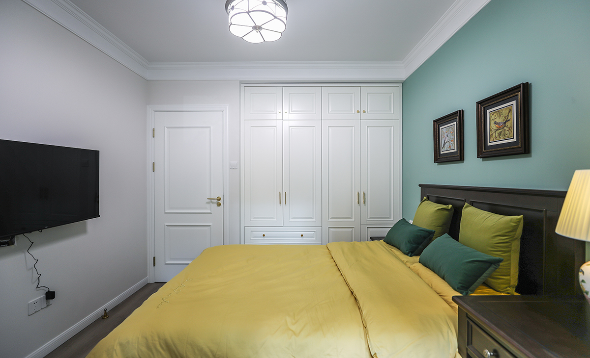 臥室選擇鋪木地板，深一些的復(fù)古做舊的色澤讓地面更有質(zhì)感。
美式實(shí)木床鋪實(shí)用又舒適，臥室的功能性俱全。通頂?shù)囊鹿裼兄呒?jí)的質(zhì)感，美式風(fēng)情處處昭顯。