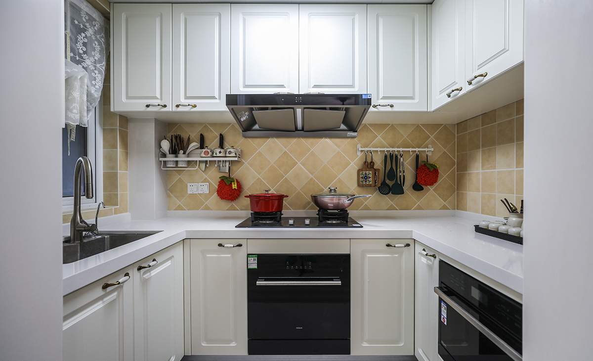 U型櫥柜滿足業(yè)主喜歡做飯的需求，棋盤格地磚讓整體不顯單調(diào)，?淺的地柜做開放式，可以放一些瓶瓶罐罐。