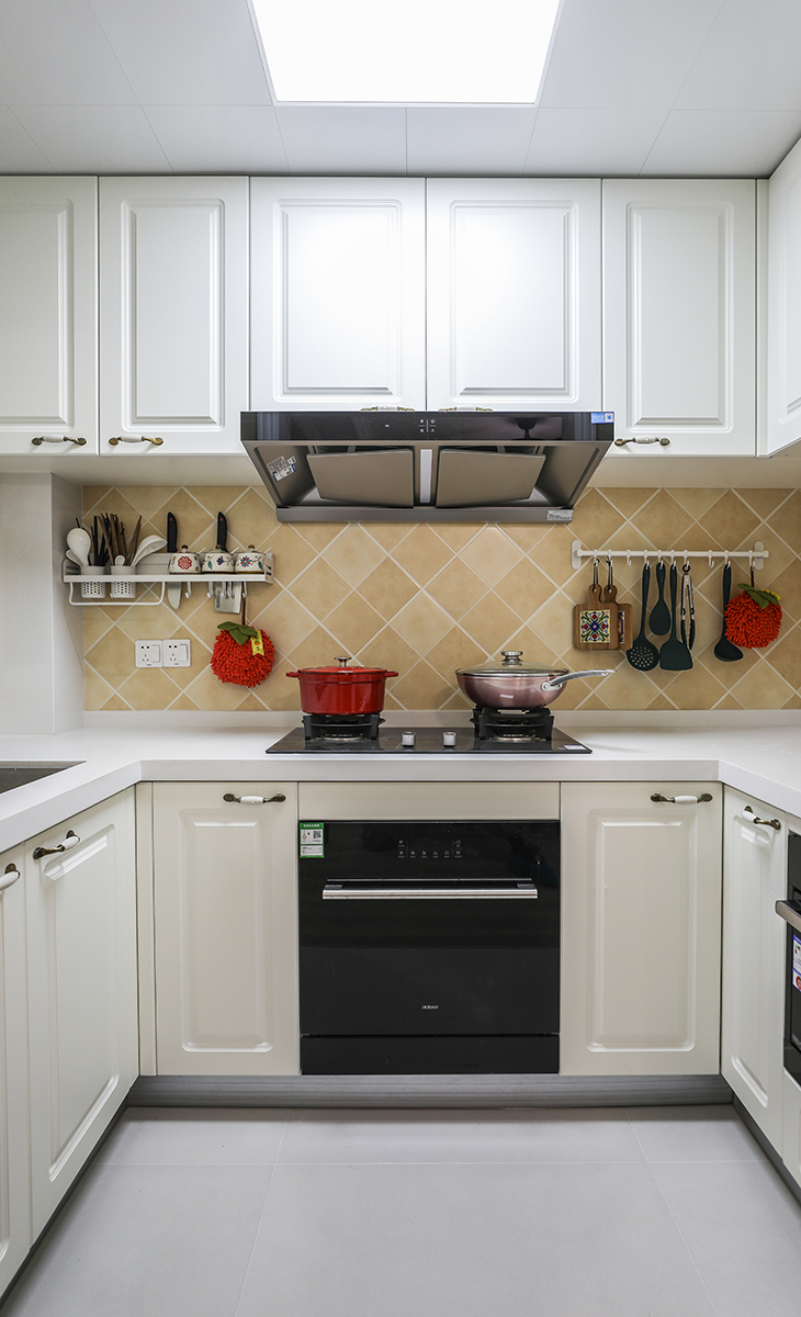 U型櫥柜滿足業(yè)主喜歡做飯的需求，棋盤格地磚讓整體不顯單調(diào)，?淺的地柜做開放式，可以放一些瓶瓶罐罐。