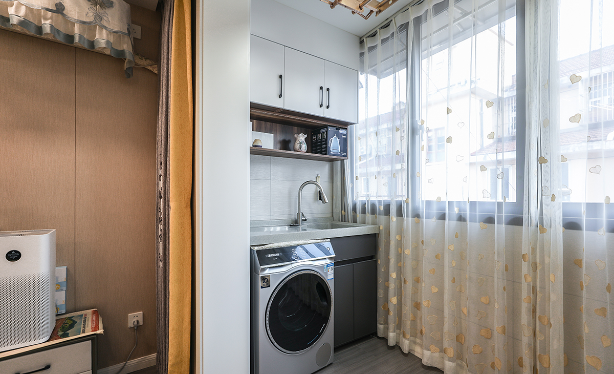 有人喜歡把洗衣機放在衛(wèi)生間，可是現(xiàn)在的戶型普遍不大，衛(wèi)生間空間不夠，怎么辦呢？陽臺剛好合適，洗完直接晾曬，不用搬著衣服往陽臺跑，上方定制柜，放置雜物的同時，還能打造一個小型洗衣池，手洗的時候不用占據(jù)洗臉池。