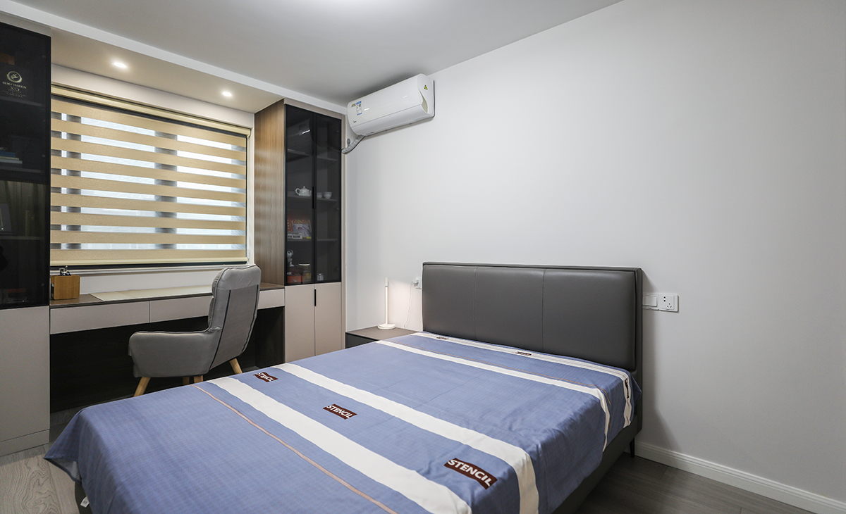 次臥整體采用了簡約自然的風格，白色墻壁和木地板的搭配，給人一種溫馨舒適的感覺。家具方面，選擇了一張床、一個書桌、一個椅子，簡潔實用，符合現代人追求簡約的生活方式。在色彩上，以白色主，營造出一種自然清新的氛圍。整個設計注重細節，比如床頭燈、裝飾畫等小物件，都為臥室增添了一些溫馨和浪漫的氣息。