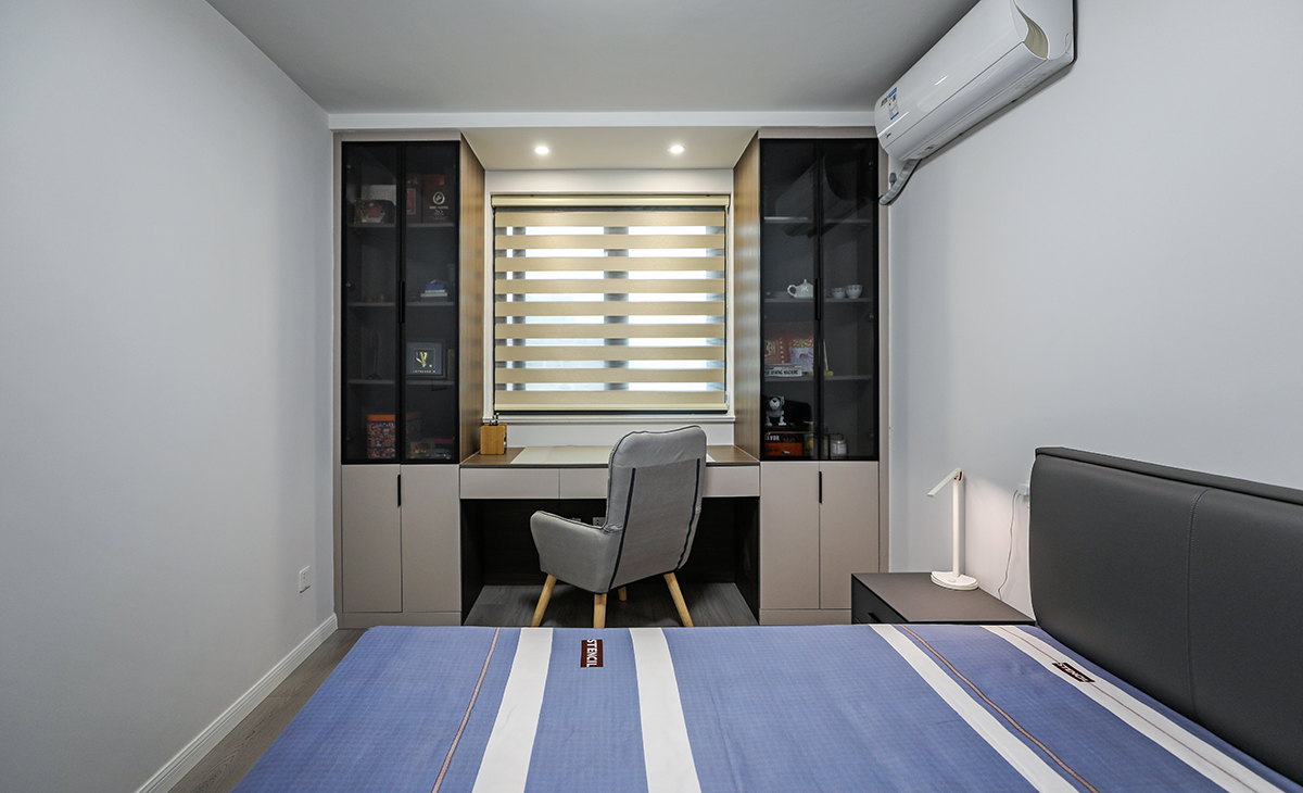 次臥寫字臺兩側，也做了玻璃柜，平時做書房用，供外孫住，設計上注重舒適和實用性，同時也考慮到了居住者的個性和審美需求。整個設計給人一種清新、自然、舒適的感覺。