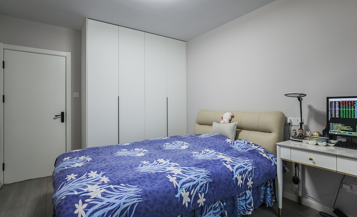 主臥地板為中性色，顏色不灰也不暖，所以床選擇的是奶油色，衣柜門板也是白色，這樣和原來的實木地板進行搭配，就不會那么突兀。白色的書桌白色的木門使整個空間更加時尚、簡約。墻面的涂料材料選用環保、無甲醛的多樂士優質，以保證家居環境的健康與安全。