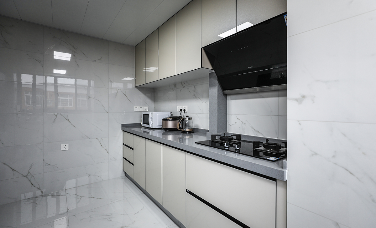 該套房子廚房空間很大，L型兩面櫥柜，另外冰箱邊上也有操作臺，顏色簡潔明快，材質(zhì)要干凈和好打理，白色的吊頂和米色的櫥柜相呼應(yīng)，各種廚房電器全部。