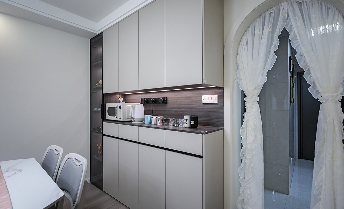 本套房子的玄關(guān)設(shè)計(jì)也是一大亮點(diǎn)，入戶玄關(guān)是一個(gè)緩存過度地段，門口的換鞋柜方便換鞋，使空間更加完善，中間和下方漏空的鞋柜，隨手可以放置包包，鑰匙等，既實(shí)用，又有裝飾性。