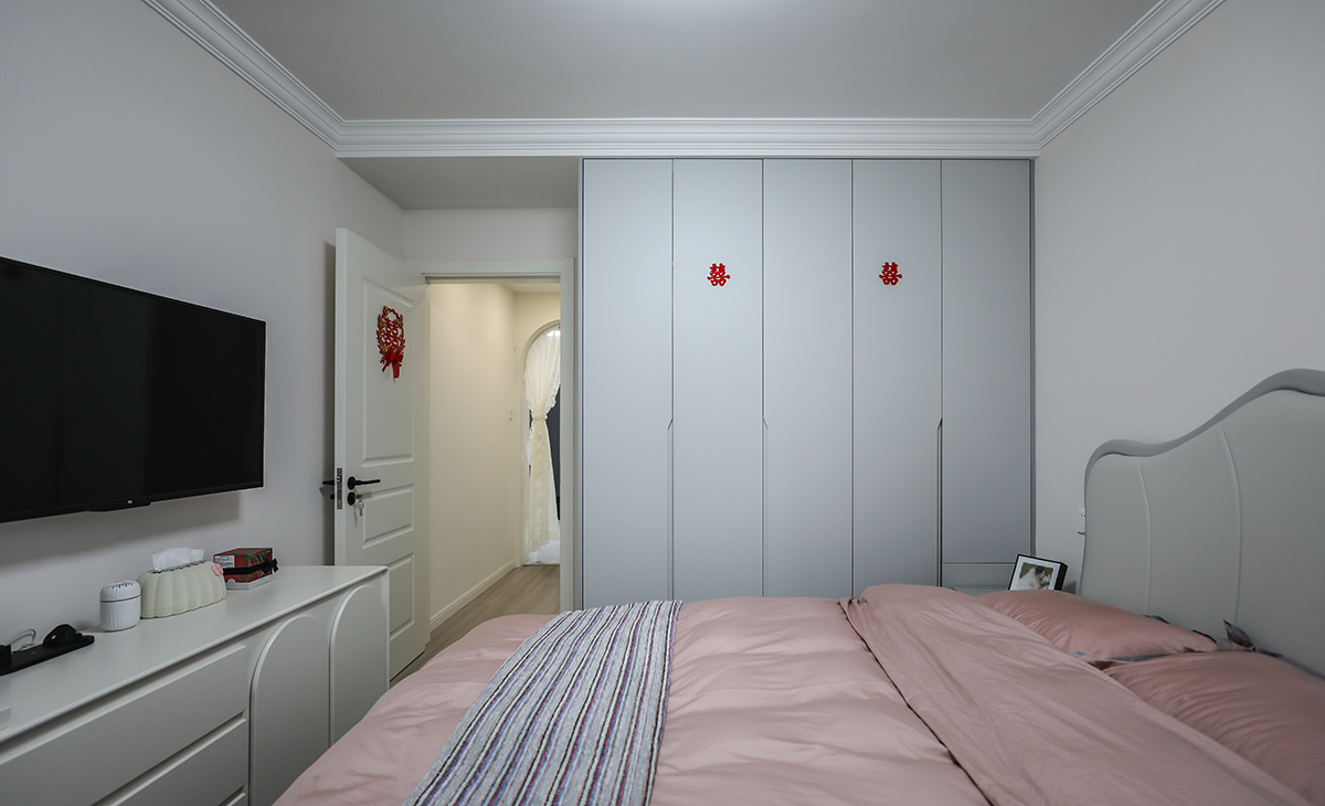 主臥做了到頂?shù)囊鹿瘢黾觾?chǔ)藏，既美觀又實(shí)用，顏色上深淺搭配地錯(cuò)落有致，淺灰木色地板，墻面暖白色干凈清爽，頂面白色乳膠漆，輕巧時(shí)尚的吸頂燈，空間很溫馨和諧。