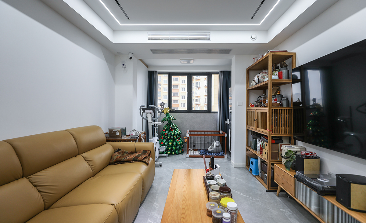 客廳是一家人活動頻率最高的區域，要求寬闊、明亮。卡其色沙發加上淺灰色地磚，頂面無主燈的設計，強調空間的整潔和舒適性，整體給人以簡潔、大氣、時尚的感覺。